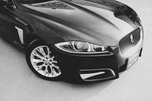 Black and white image of a luxury Jaguar car highlighting its sleek design and elegant curves.